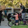 Police Officer Wade Stern, with the University of California Riverside Police Department, arrives with pizza as Jet Wilbur, 6, of Riverside, and his father, Robert Wilbur, a Master’s student of educational psychology in the School of Education, help push donated bikes from UCPD to Oban Family Housing on Friday, September 17, 2021. (UCR/Stan Lim)