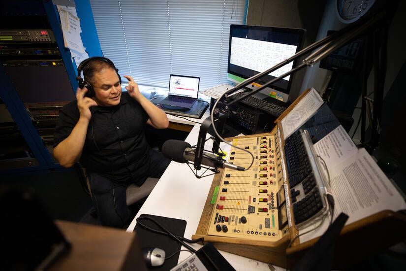 Richard T. Rodríguez, professor of English and media and cultural studies, is also a DJ on KUCR. He appears every Thursday night as "Dr. Ricky on the Radio." On Thursday, September 1, 2022, he prepared to go on the air.  (UCR/Stan Lim)