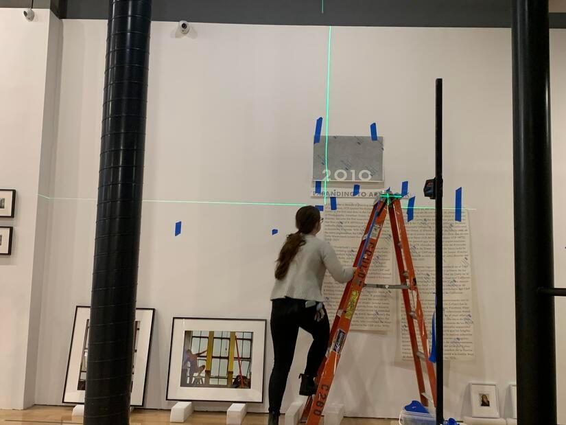 Grace Saunders, exhibition and design assistant, works on wall text for the California Museum of Photography's "CMP at 50" exhibition on March 7, 2023. (UCR/Sandra Baltazar Martínez) 