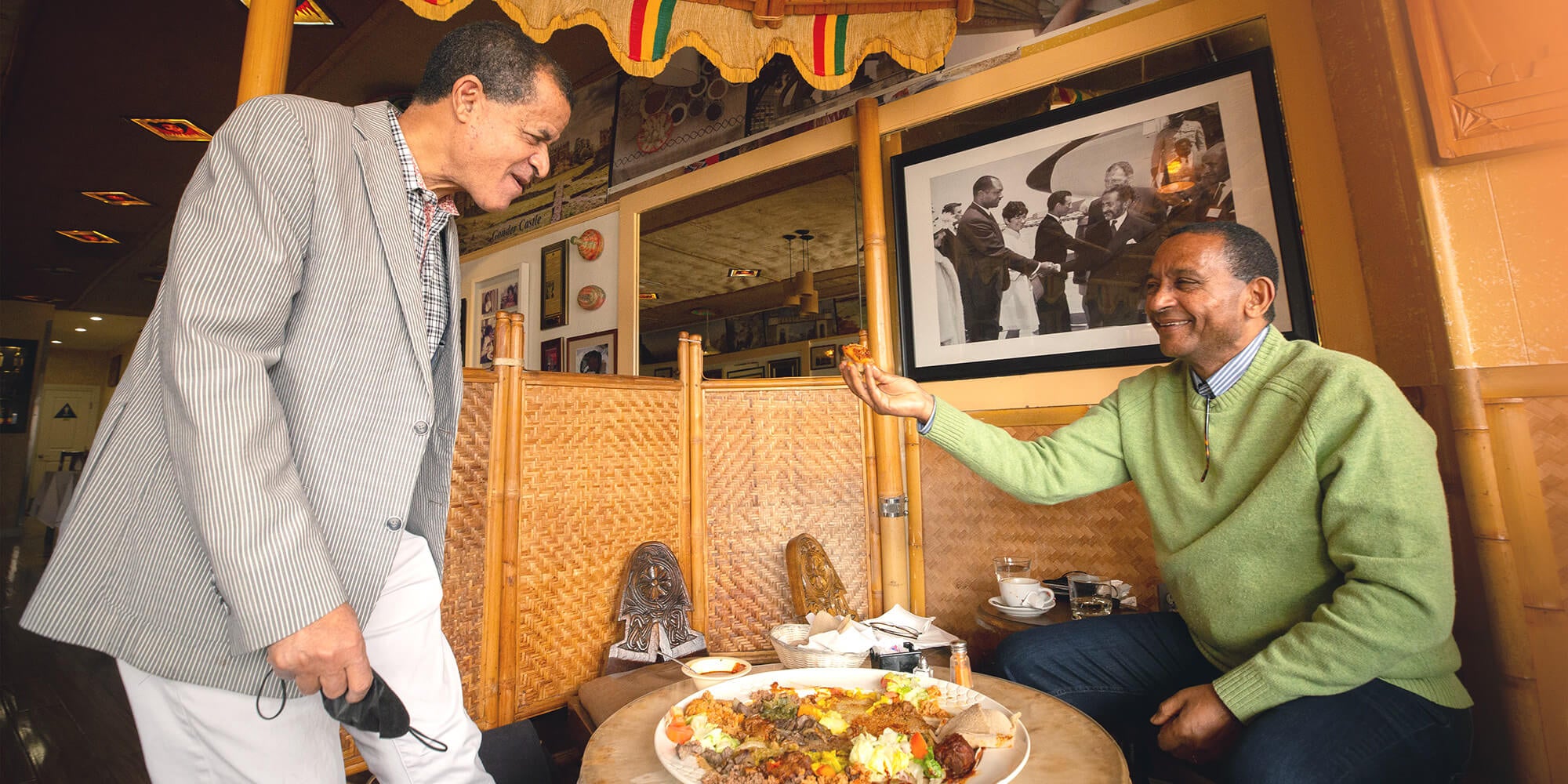 Berhanu Asfaw (left), owner of Messob, shares food with Worku Nida.
