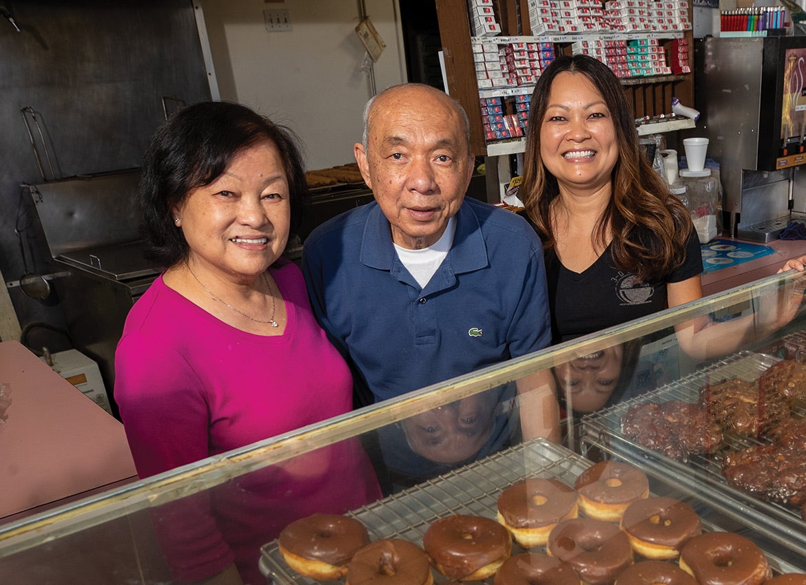 Ratmony Yee (right) stands with her parents at 3-D Donuts, the family’s donut shop in  Highland, California.