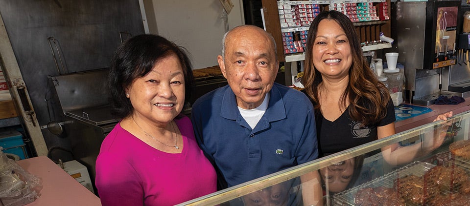 Ratmony Yee (right) stands with her parents at 3-D Donuts, the family’s donut shop in  Highland, California.