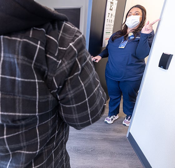 A health care worker greets a patient at UCR's Hulen Place health clinic. 