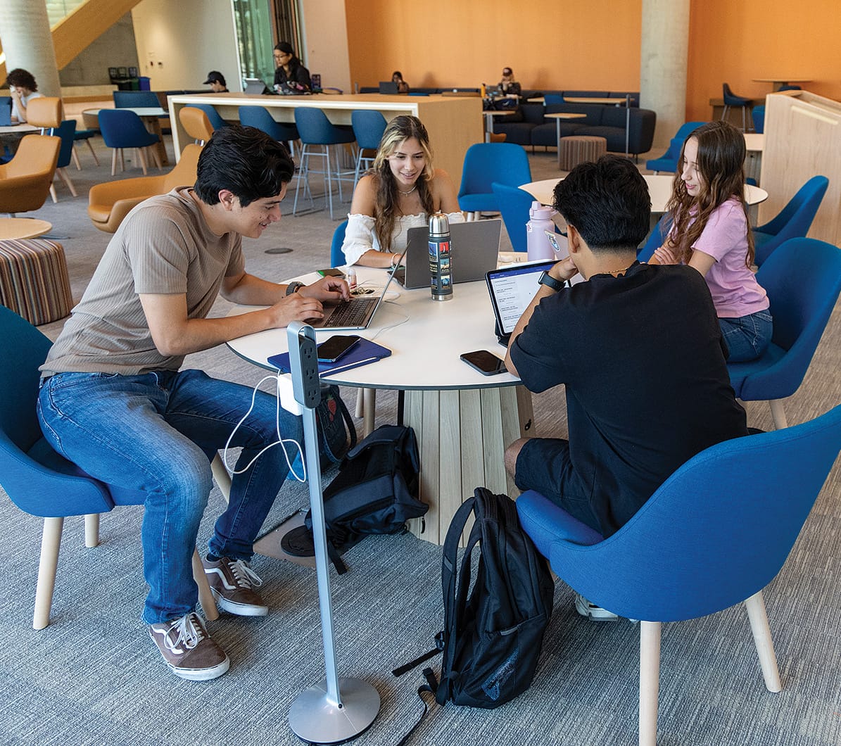 UCR students sitting at a study area on the first floor lobby