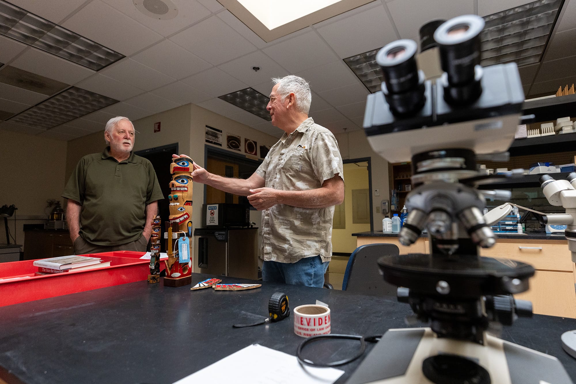 Goddard (left) chats with Edgard Espinoza, criminalistics section chief, at the lab.