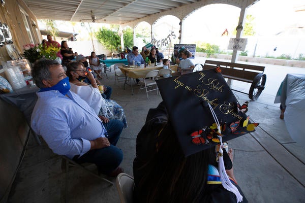 Jacqueline Hernandez Rico, 33, watches the Raza Grad online with her family at her parent's home in Perris on Saturday, June 13, 2020. Hernandez Rico, a sociology major, and other students celebrated their graduations remotely while the campus remained closed due to the novel coronavirus. (UCR/Stan Lim)