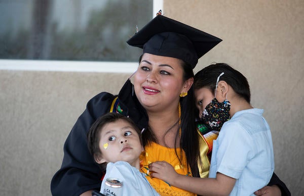 Jacqueline Hernandez Rico, 33, gets a hug from her sons Adan Sebastian Hernandez, 4, and Ivan Santiago Hernandez, 6, while watching the Raza Grad online at her parent's home in Perris on June 13, 2020. (UCR/Stan Lim)