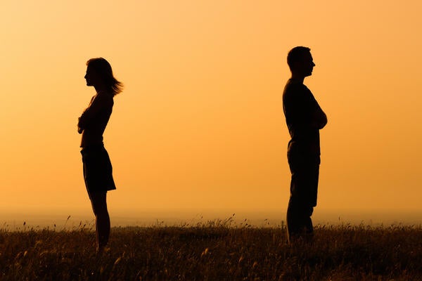 A couple facing away from each other at sunset