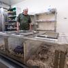 Goddard looks into chambers containing flesh-eating dermestid beetles actively removing the flesh from animal skulls and bones brought in as evidence or reference specimens.