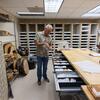 Espinoza pulls out samples of wood at the lab.