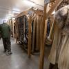 Goddard walks through a refrigerated room containing animal skins, pelts, and fur coats.