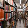 Lewis walks through an aisle of books housed in the central basement at the Huntington.