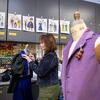 Landis Maren York assembles a costume in front of a collection of design sketches created for the production.