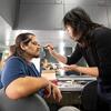 Student Eric Ortiz (left), who played the role of Dracula, has stage makeup applied by student Aliche Zhang in the dressing room during the final dress rehearsal.