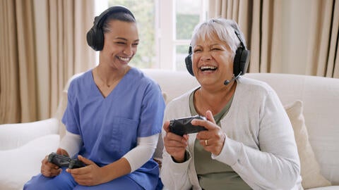 older person and nurse playing video games