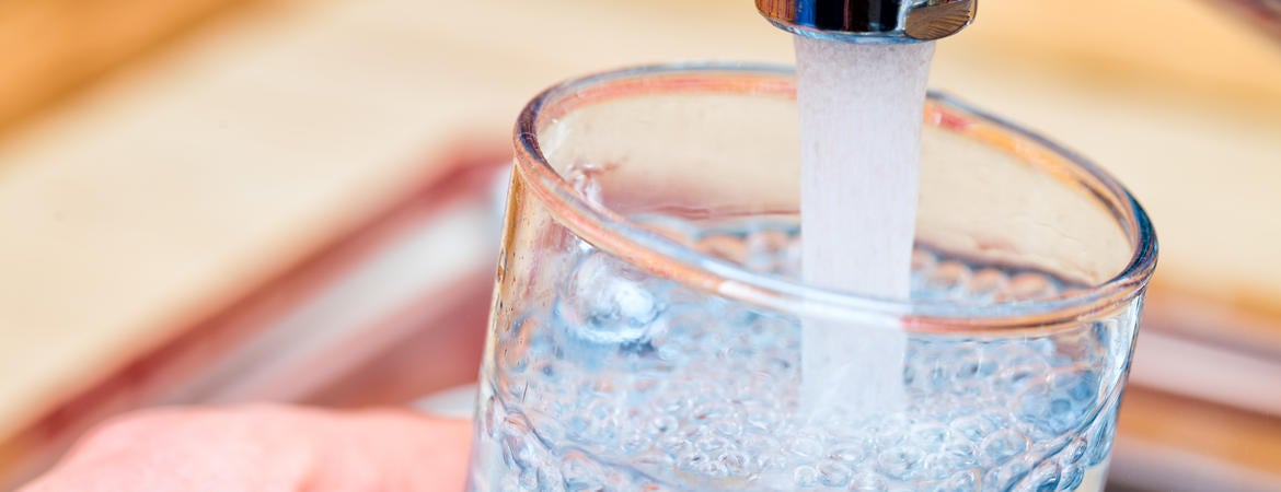 A picture of someone filling a glass with tap water