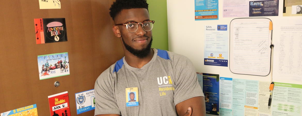 Alex Ukpong standing by the Glen Mor apartment door. 