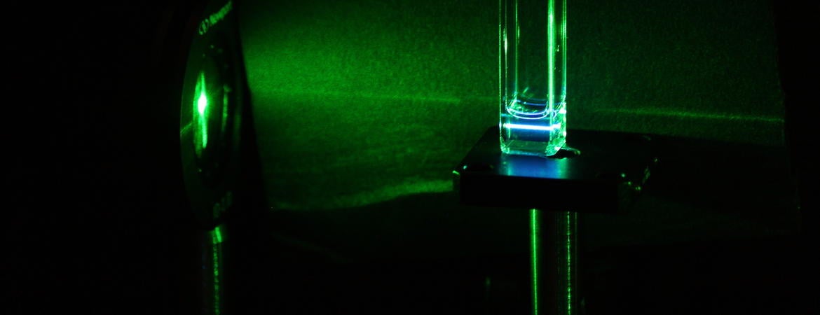 A green laser light going through the silicon quantum dots, and the silicon quantum dots re-emitting blue light (i.e. upconversion).