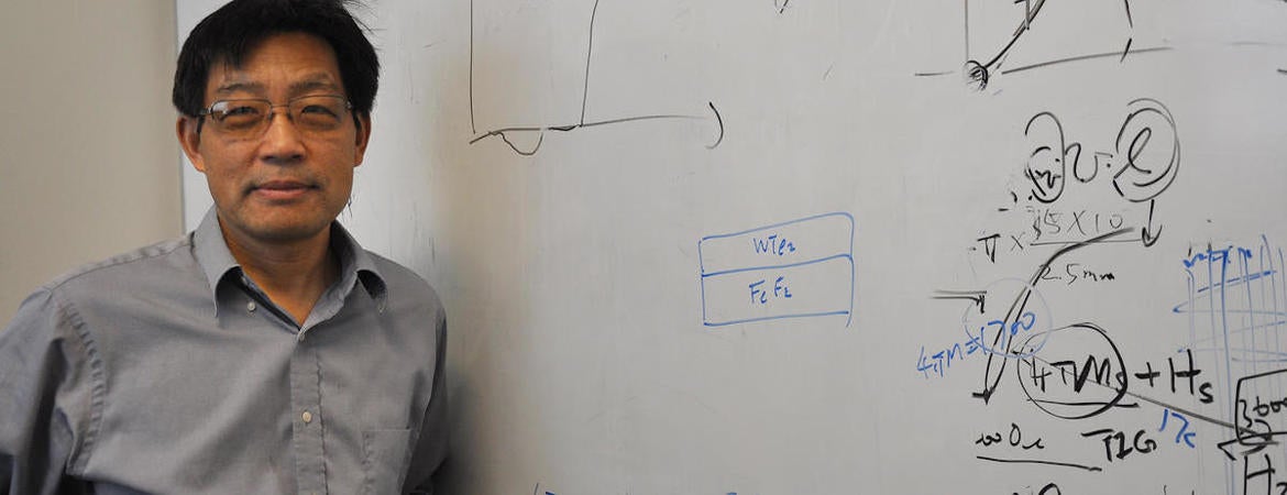 Researcher Jing Shi stands in front of white board