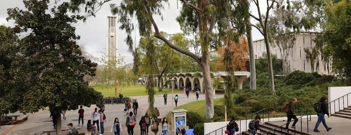 Students walk in between classes at UC Riverside. The bell tower is seen in the distance