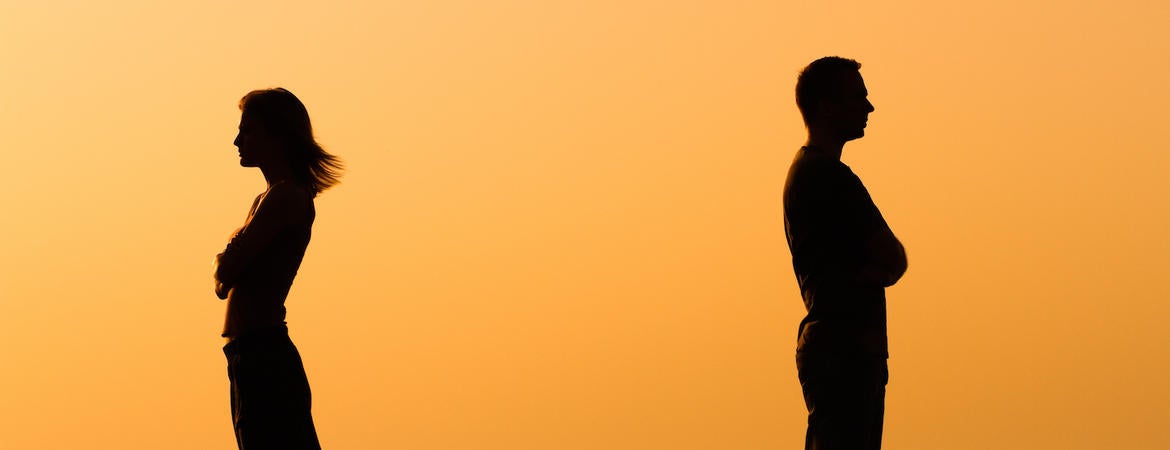 A couple facing away from each other at sunset