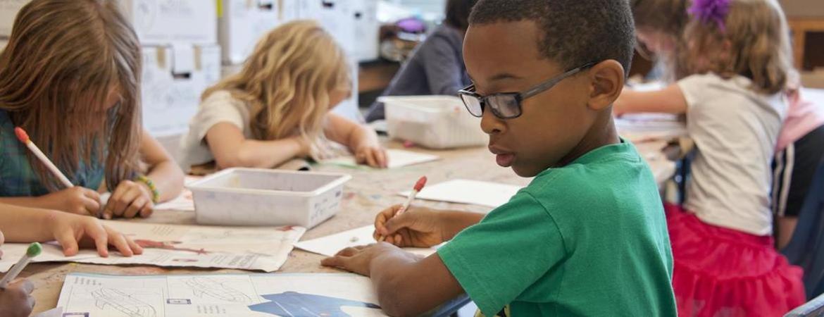 A Black student is shown in an elementary school setting amongst white peers