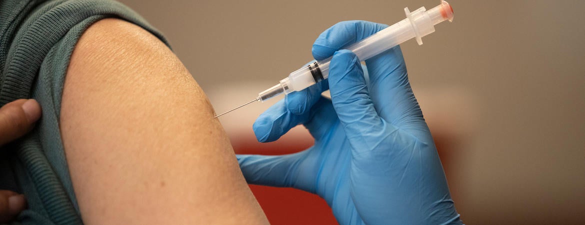 A person's arm is shown getting the vaccine