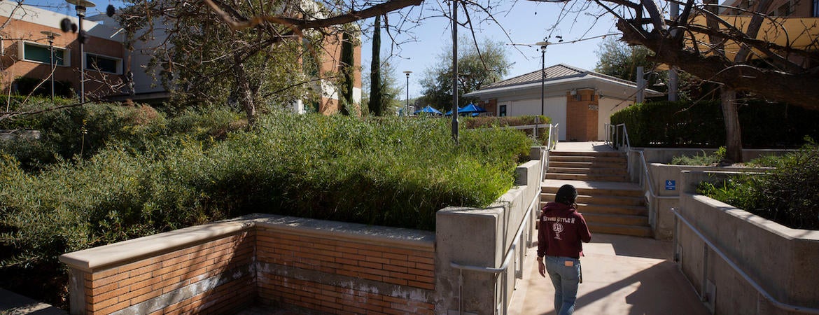 A student walks on a lonely campus near the School of Medicine building
