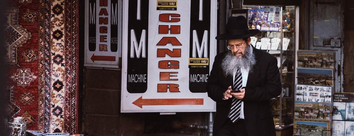 A Jewish man walks through a market place. 