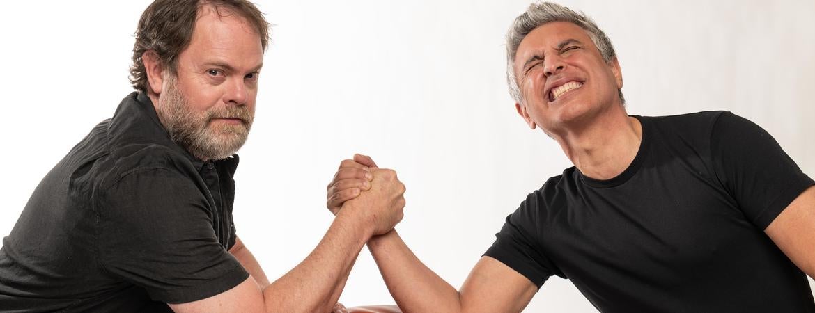 Rainn Wilson and Reza Aslan arm wrestling