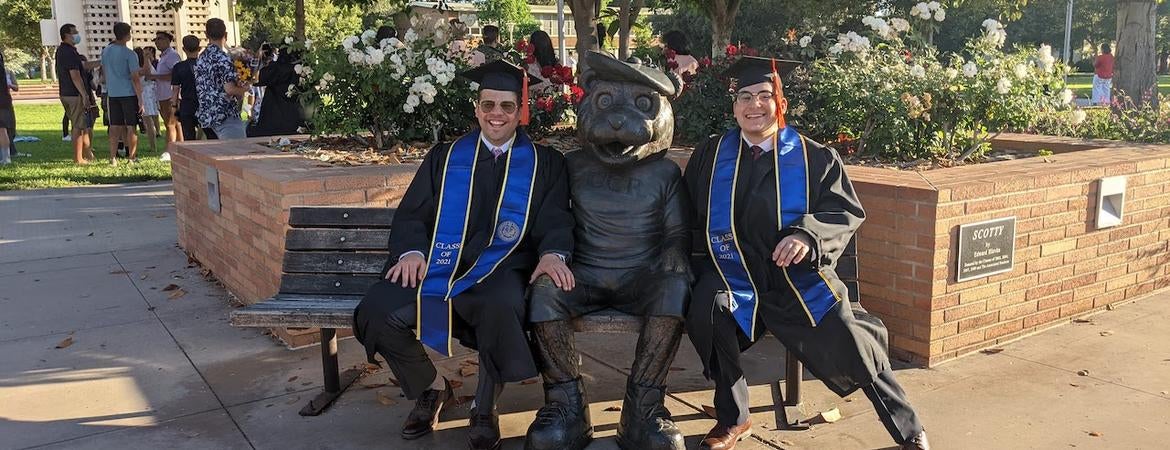 Mahmood Shaheen and Nathaniel Ortiz sit with Scotty before a commencement ceremony