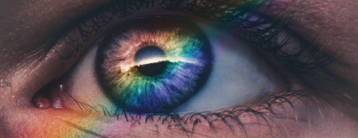 A rainbow falls across a person's eye