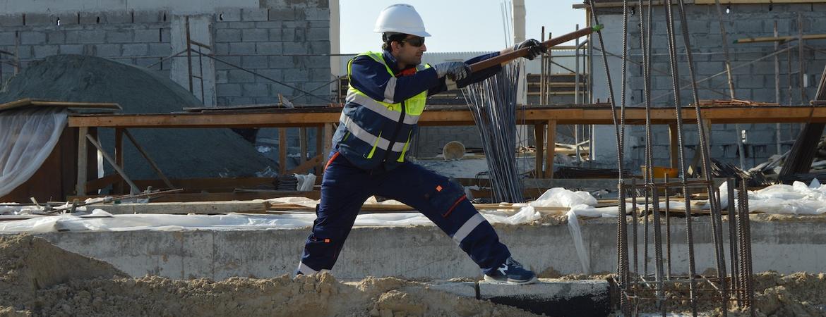 A construction worker bends rebar