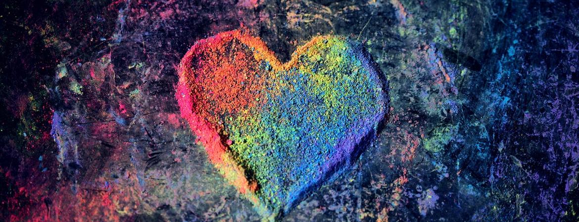 An LGBT-themed heart made of rainbow chalk dust