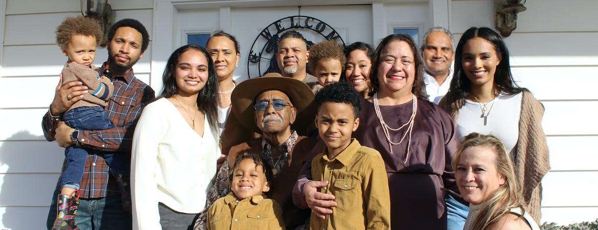 A family stands in front of a house