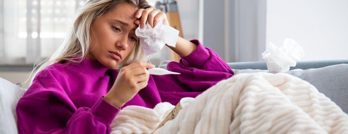 A woman sick on the couch with the flu