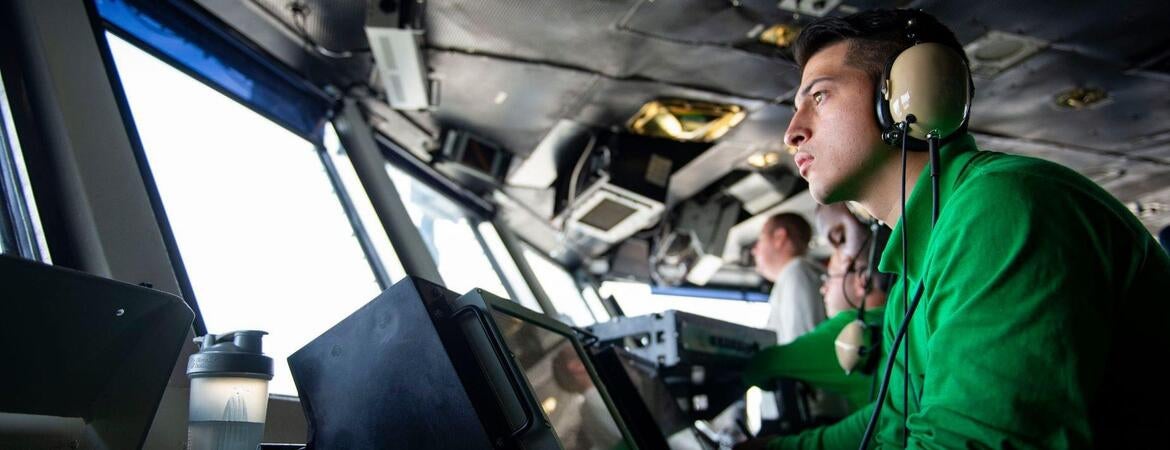 Military at ship control panels