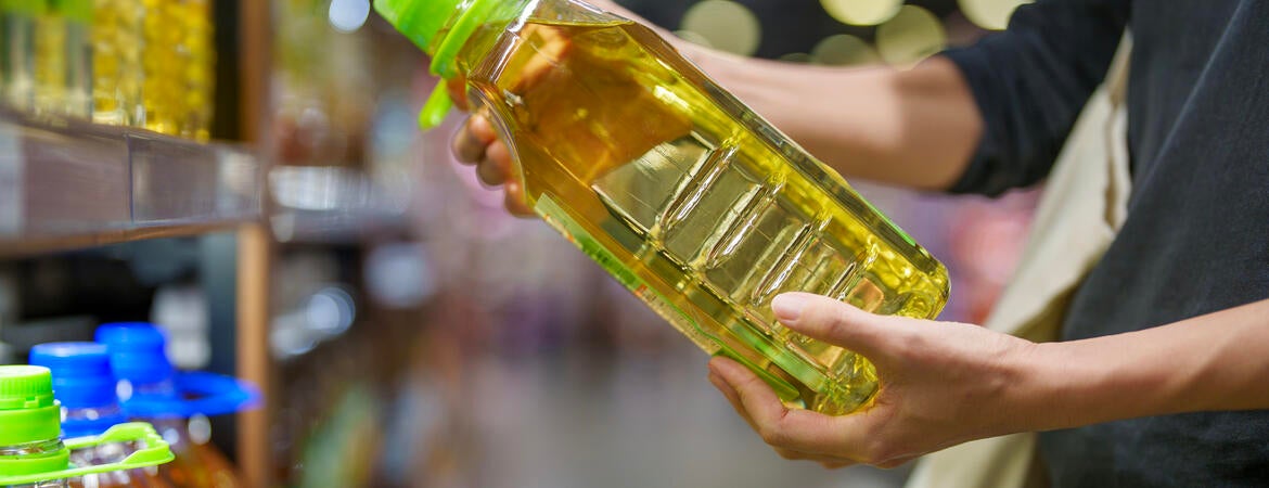 shopper holding bottle of oil