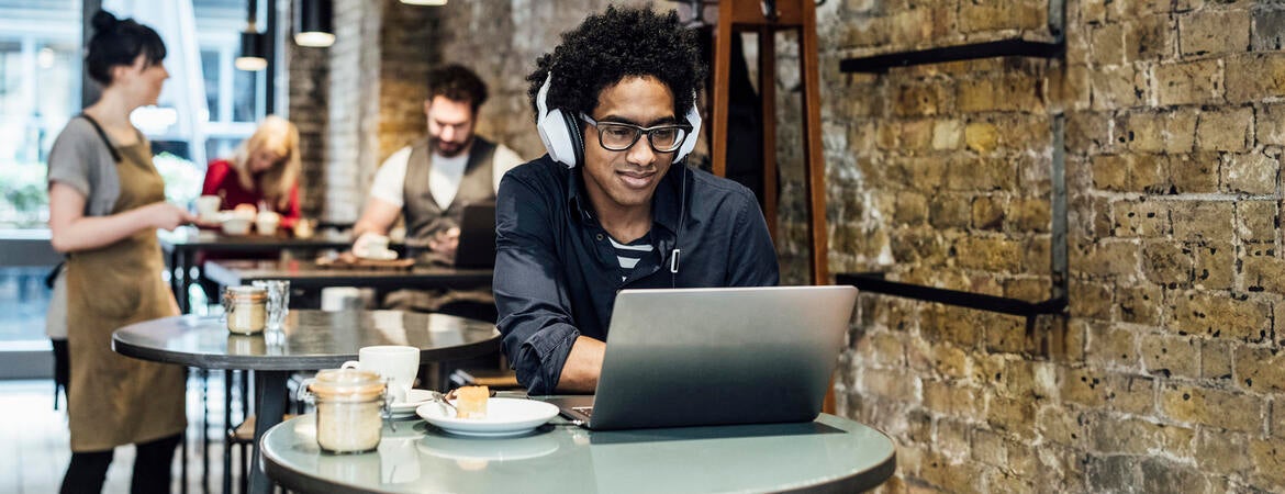 Man using a laptop in a coffee shop