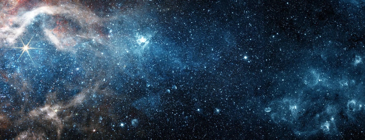 An image of space filled with stars, galaxies, and a nebula.