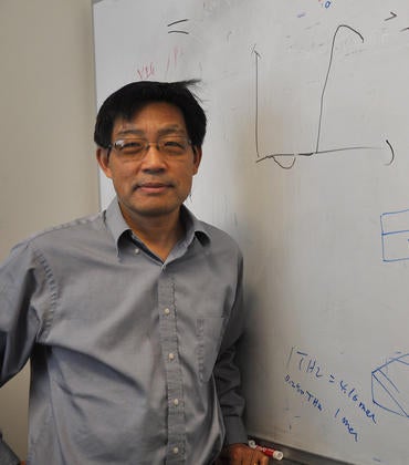 Jing Shi standing in front of white board