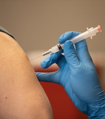 A person's arm is shown getting the vaccine