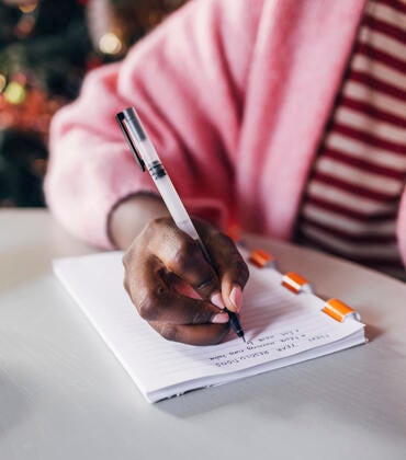 Woman writing her New Year's resolutions