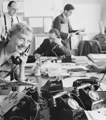Young woman working with male colleagues in an English PR firm in 1954