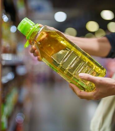 shopper holding bottle of oil