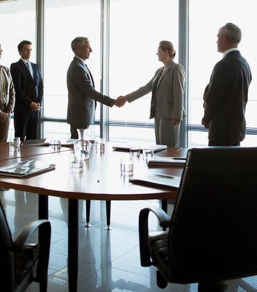 Corporate board room handshake