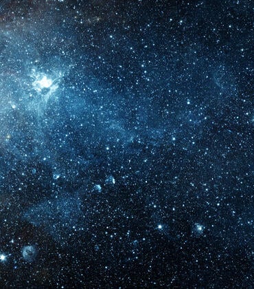 An image of space filled with stars, galaxies, and a nebula.
