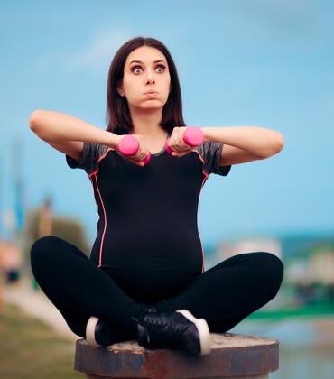 Pregnant woman holding weights