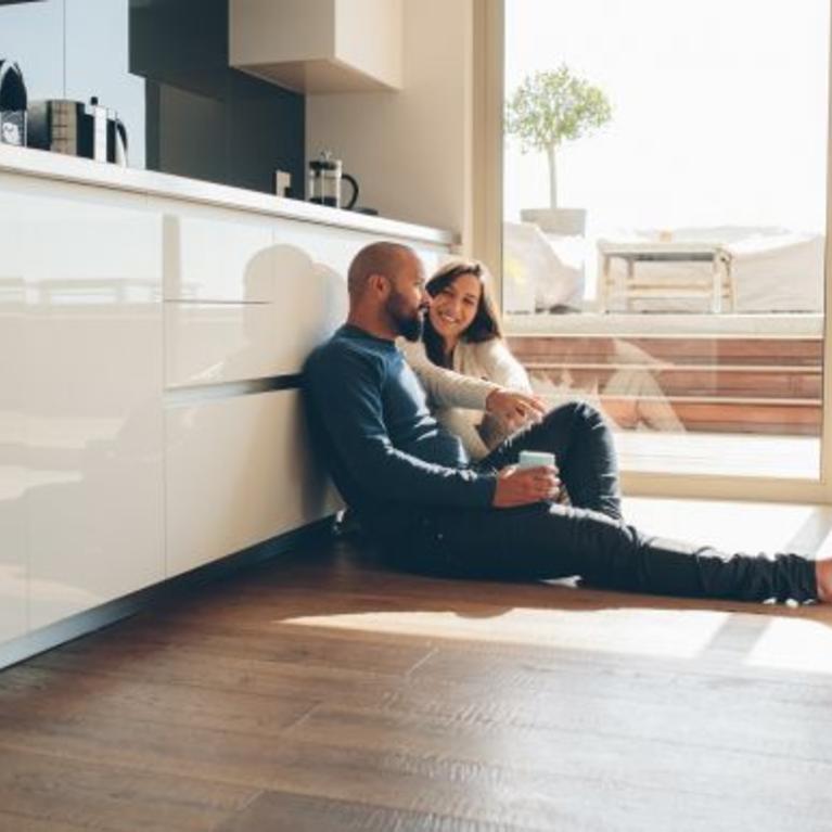 couple sitting on floor of kitchen