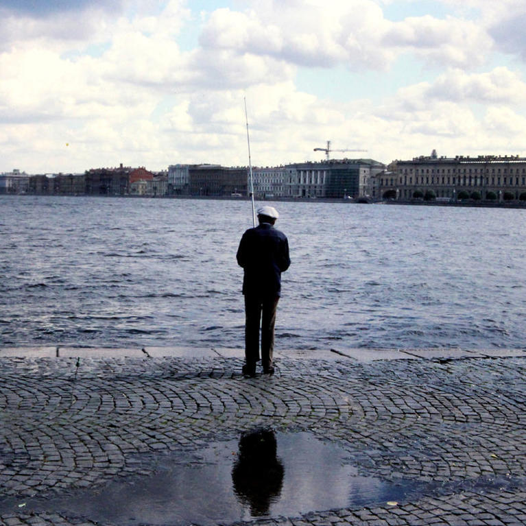 Fisherman against skyline of Leningrad, USSR, now St. Petersburg, Russia